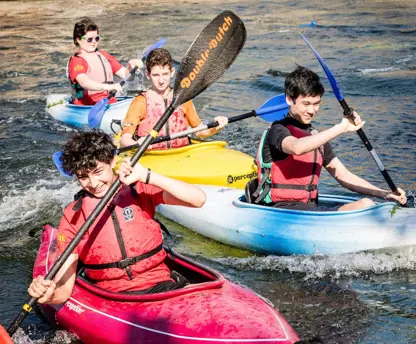 four young people in canoes