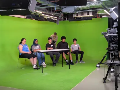 young people sitting at table being filmed